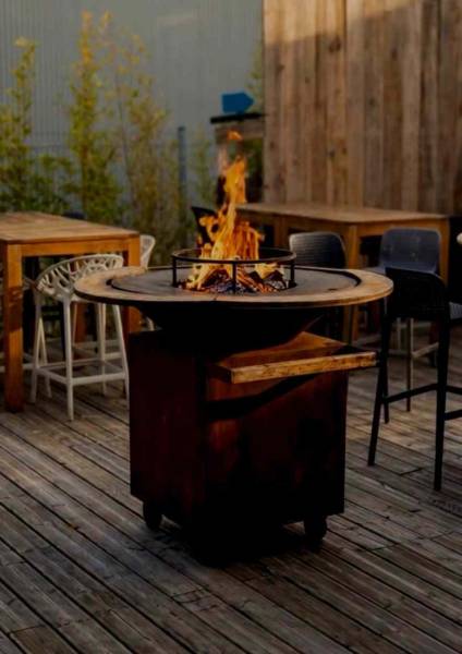 Brasero avec flammes sur terrasse du restaurant La Ville en Rose